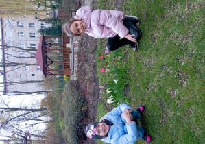 Dziewczynki pozują do zdjęcia przy kwitnących tulipanach